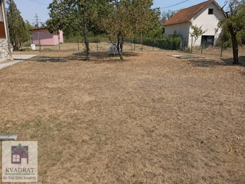 Pogled na prostrano travnato dvorište sa voćnjakom i pomoćnim objektom u pozadini. - image 18