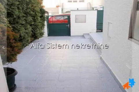 Tiled courtyard in front of the house entrance with a gate and greenery. - image 27