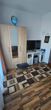 Namještena spavaća soba sa ormarom, radnim stolom i televizorom. - image 7