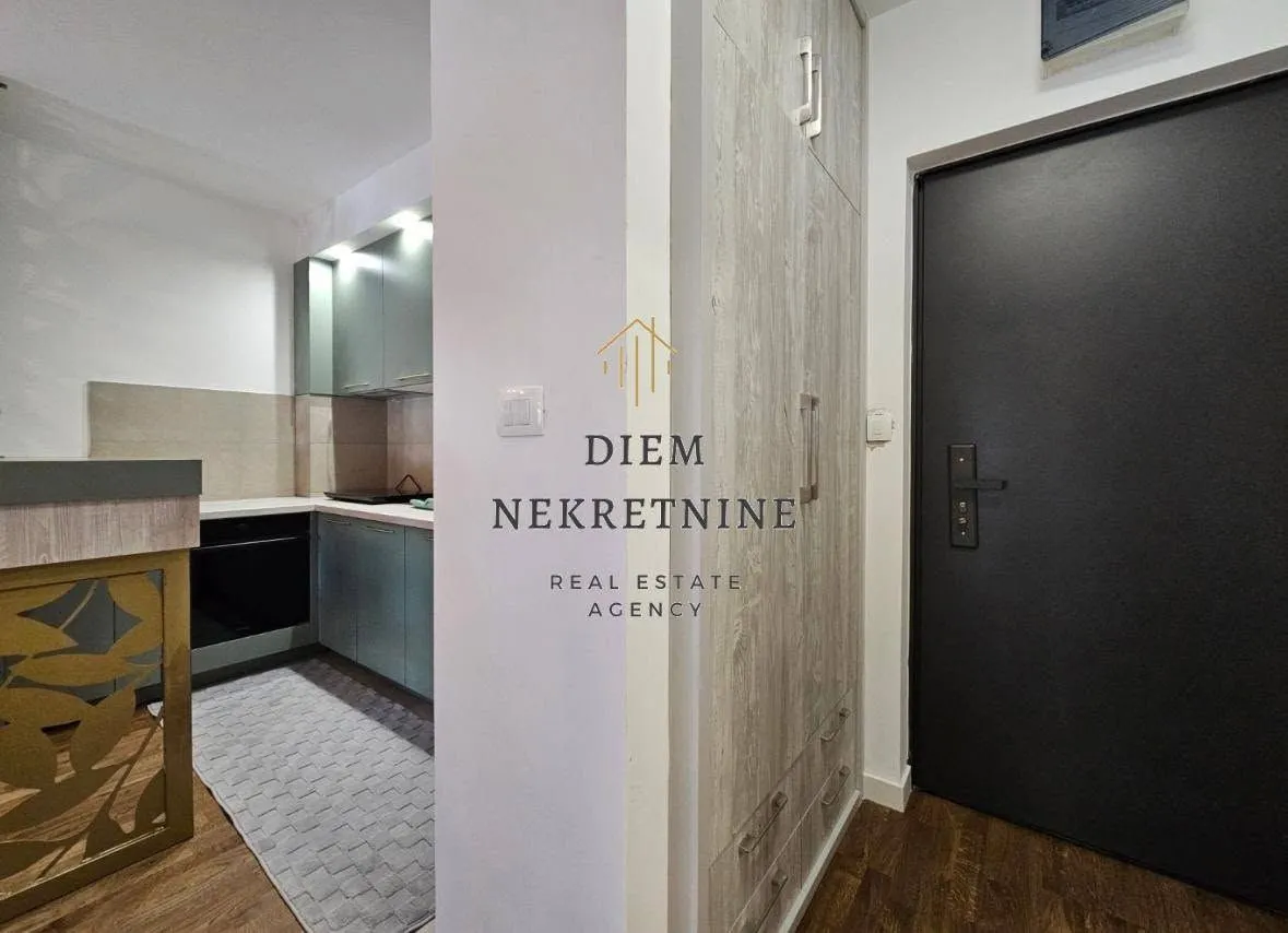 View of a modern equipped kitchen and hallway with an entrance door.