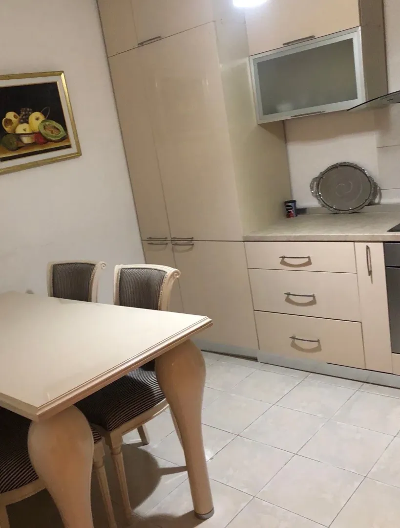 Trpezarija sa stolom i stolicama u nastavku kuhinje.