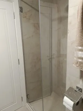 Modern bathroom with a walk-in shower and marble tiles. - image 5