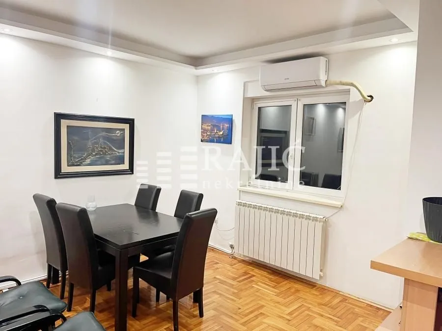 Dining area with a black table and chairs in an apartment.
