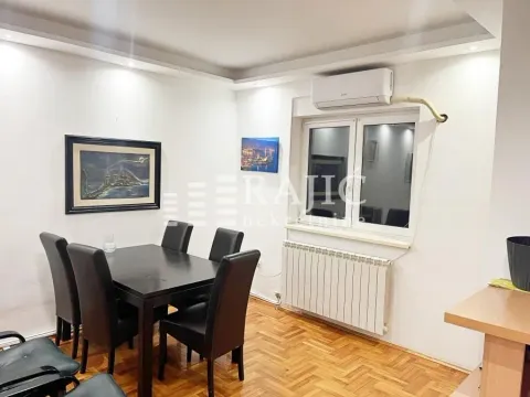 Dining area with a black table and chairs in an apartment. - image 2