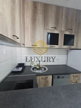 Modern kitchen with wooden cabinets and a dark countertop. - image 2