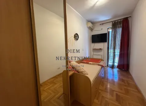 Smaller bedroom with a bed, wardrobe, and balcony access. - image 5