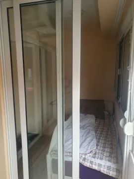 A small bedroom with a bed behind sliding doors. - image 20