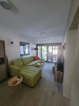 Dnevna soba sa zelenom ugaonom garniturom i izlazom na terasu. - image 8