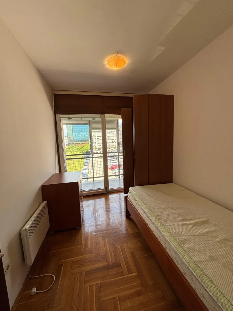 Smaller bedroom with a bed, wardrobe, and access to the terrace.