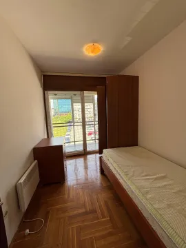 Smaller bedroom with a bed, wardrobe, and access to the terrace. - image 10