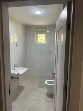 Pogled kroz otvoren vrata na moderno opremljeno kupatilo sa tuš kabinom. - image 11