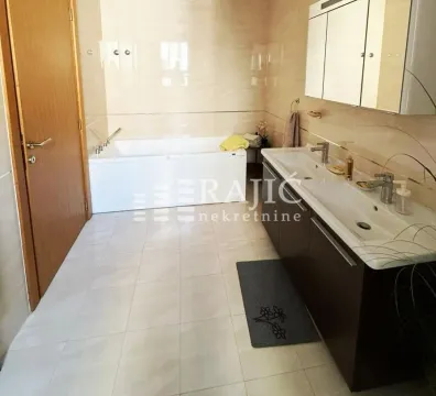 Spacious bathroom with a bathtub and double vanity. - image 5