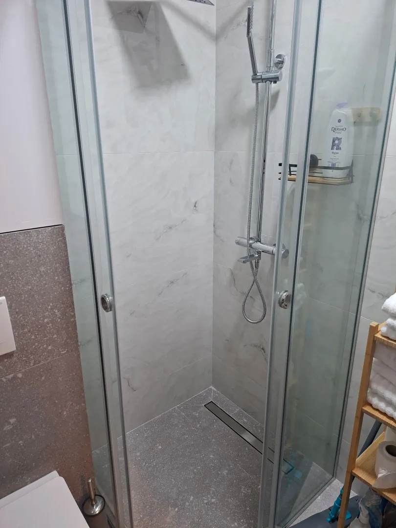 Modern walk-in shower with a glass screen in the bathroom.