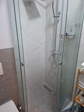 Modern walk-in shower with a glass screen in the bathroom. - image 4