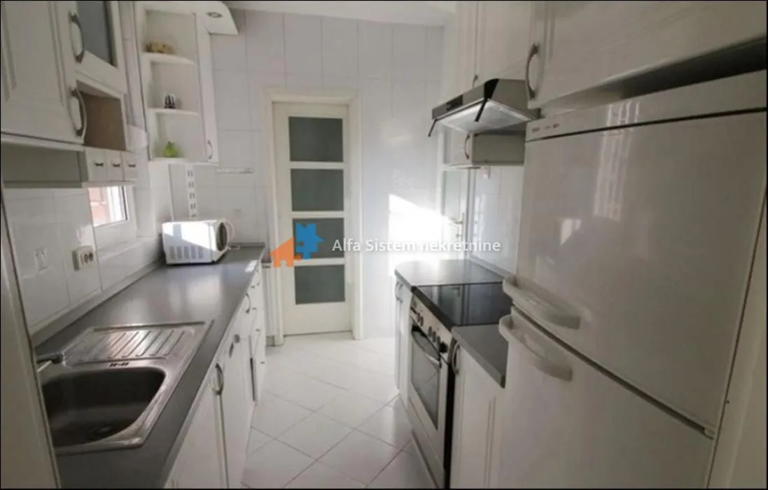 Small white kitchen with a sink, stove, and refrigerator.