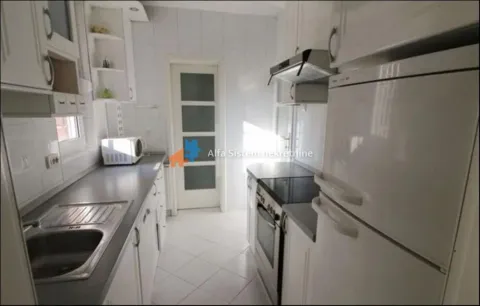 Small white kitchen with a sink, stove, and refrigerator. - image 6