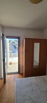Spavaća soba sa krevetom, drvenim ormarom i izlazom na terasu. - image 7