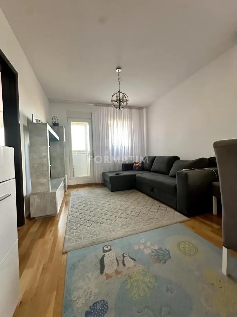 Dnevna soba sa garniturom za sedenje i izlazom na terasu.