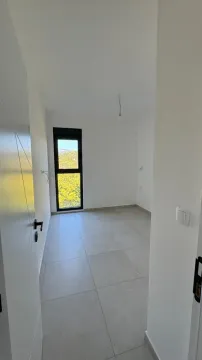 Prazna soba sa pločicama na podu i prozorom. - image 2