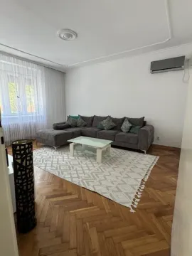 Dnevna soba sa ugaonom garniturom, klub stočićem i parketom na podu. - image 3