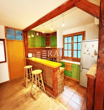 Rustic kitchen with a breakfast bar and wooden elements. - image 3