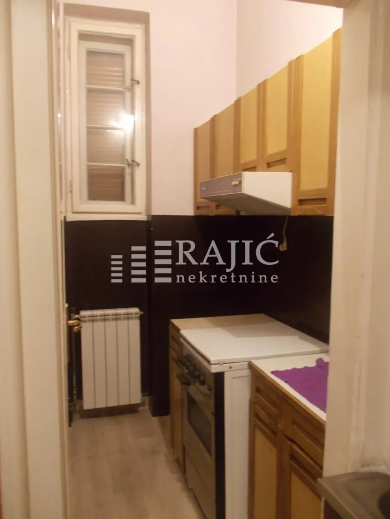 Smaller kitchen with wooden cabinets and a window.