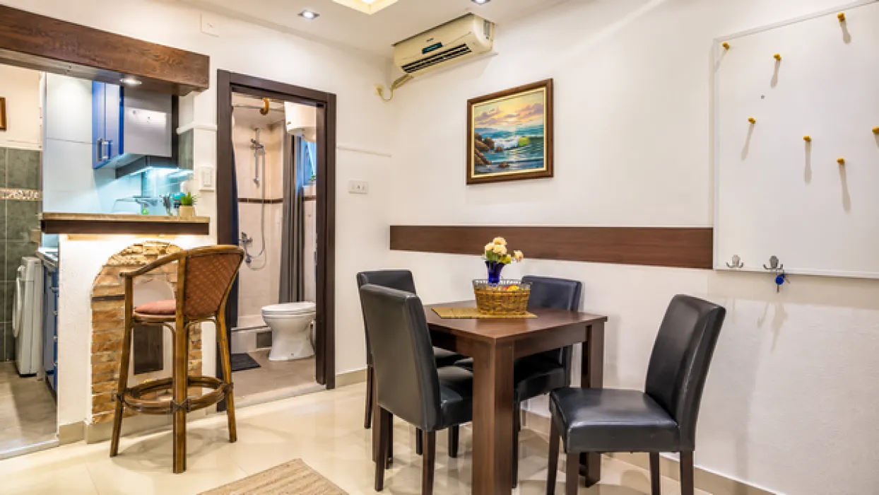 Dining area with seating and a view of the kitchen and bathroom.