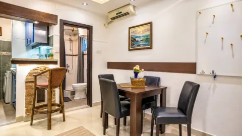 Dining area with seating and a view of the kitchen and bathroom. - image 9