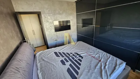 Prostrana spavaća soba sa bračnim krevetom, velikim ormarom i televizorom na zidu. - image 9