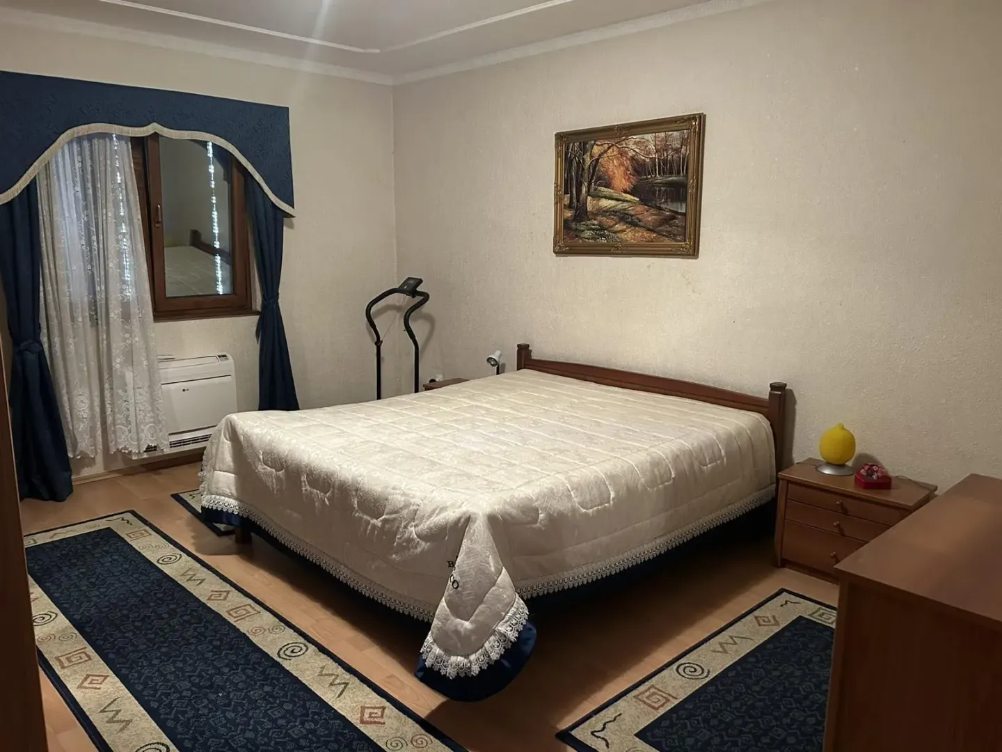 Comfortable bedroom with a large double bed and matching furniture.