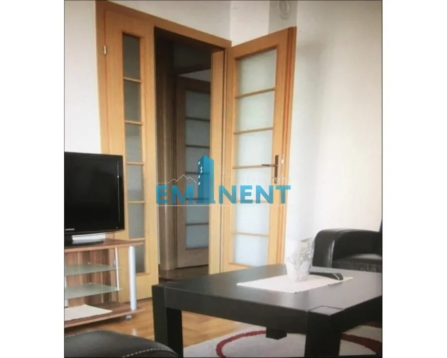 View of part of the living room with furniture and wooden doors.