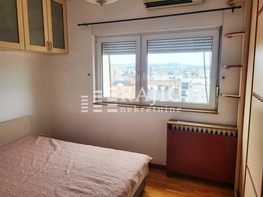 Manja spavaća soba sa krevetom i ormarima.