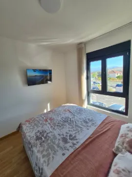 Spavaća soba sa bračnim krevetom, televizorom na zidu i prozorom sa pogledom. - image 14