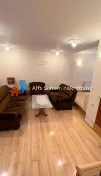 Dnevna soba sa garniturom za sedenje i drvenim podom. - image 7