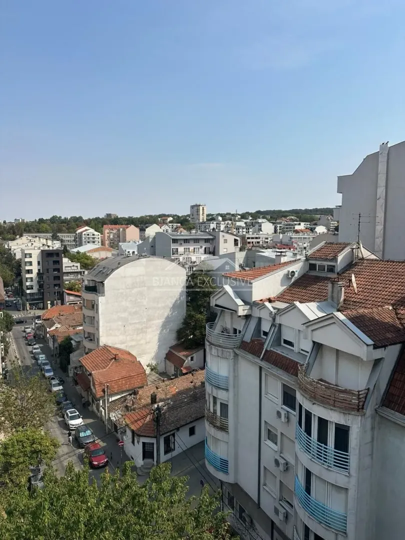 Pogled sa prozora na okolne zgrade i gradske ulice.