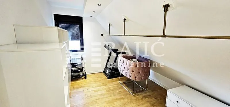 Attic room with a baby crib, storage units, and a window.