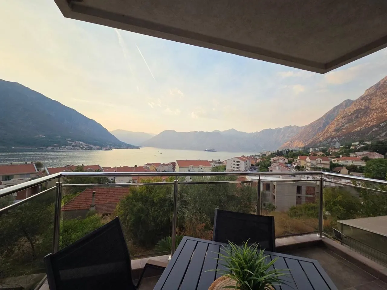 Terrace with seating furniture and a view of the sea and mountains.