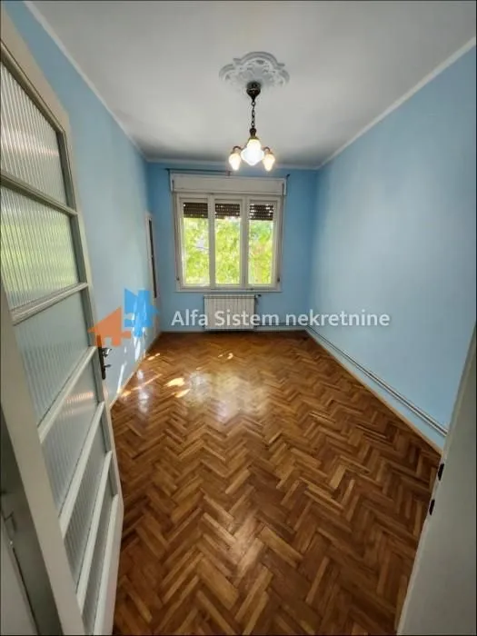 Empty room with parquet flooring and a window.
