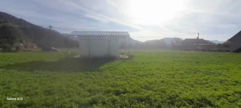 Pogled na zeleno dvorište sa manjim pomoćnim objektom i brdima u pozadini. - image 2