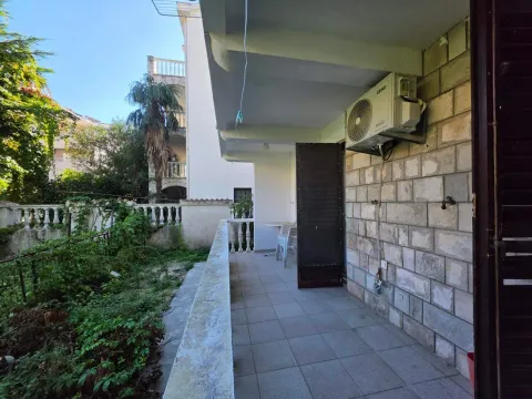 Covered terrace with a stone wall, air conditioning unit, and a view of the yard. - image 7