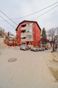 Pogled na spoljašnjost stambene zgrade i ulicu sa parkiranim automobilima. - image 19