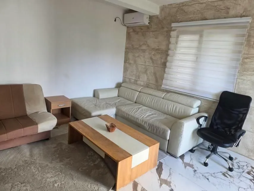 Dnevna soba sa garniturom, klub stolićem i klima uređajem.