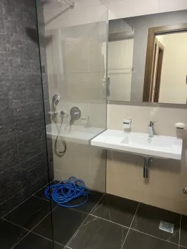 A bathroom with a glass shower cabin and a sink. - image 3