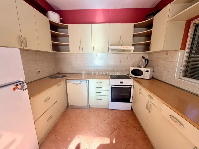 Smaller kitchen with light-colored cabinetry and built-in appliances.