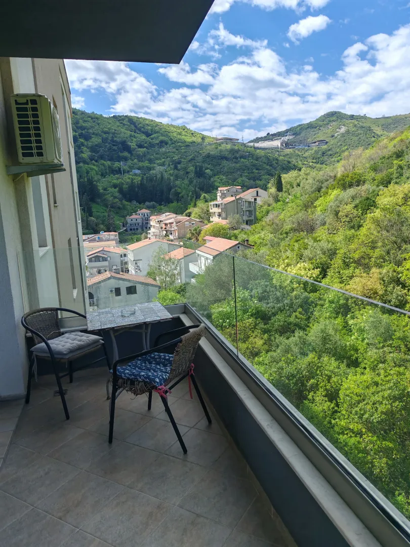 Furnished terrace with seating furniture and a view of nature and the settlement.