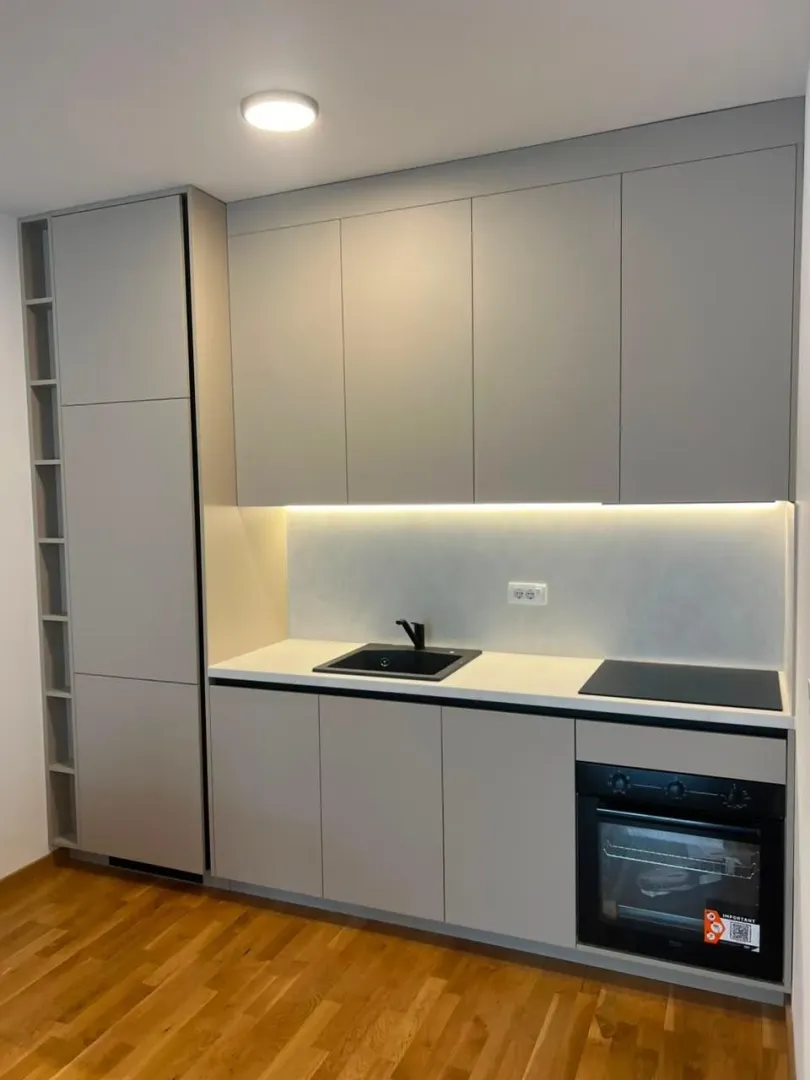 Modern kitchen with grey cabinets and a built-in oven.