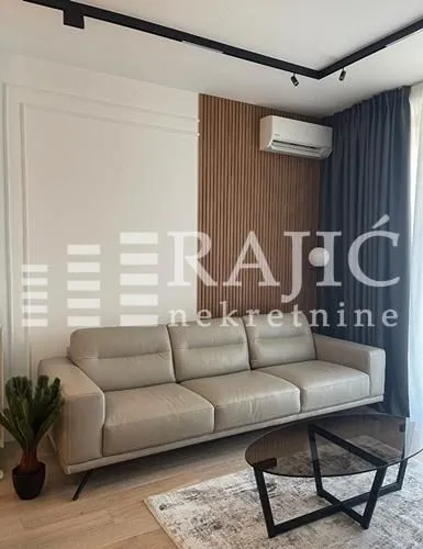 Modern living room with a sofa and a decorative wooden wall panel.
