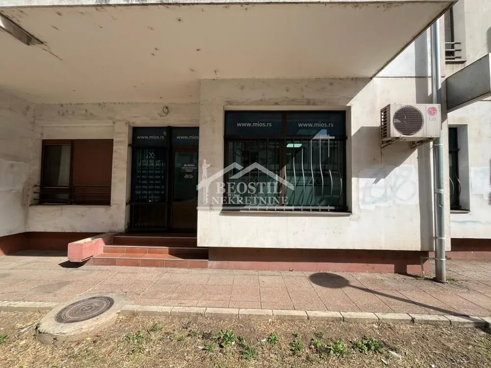 Exterior view of the commercial space entrance with glass shop windows.
