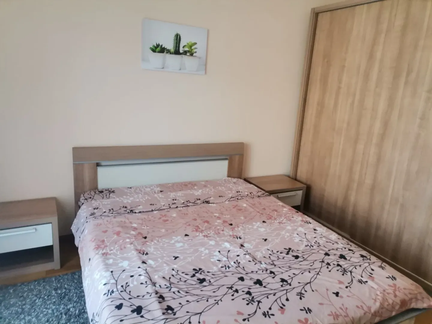 Jednostavno namještena spavaća soba sa bračnim krevetom i ormarom.