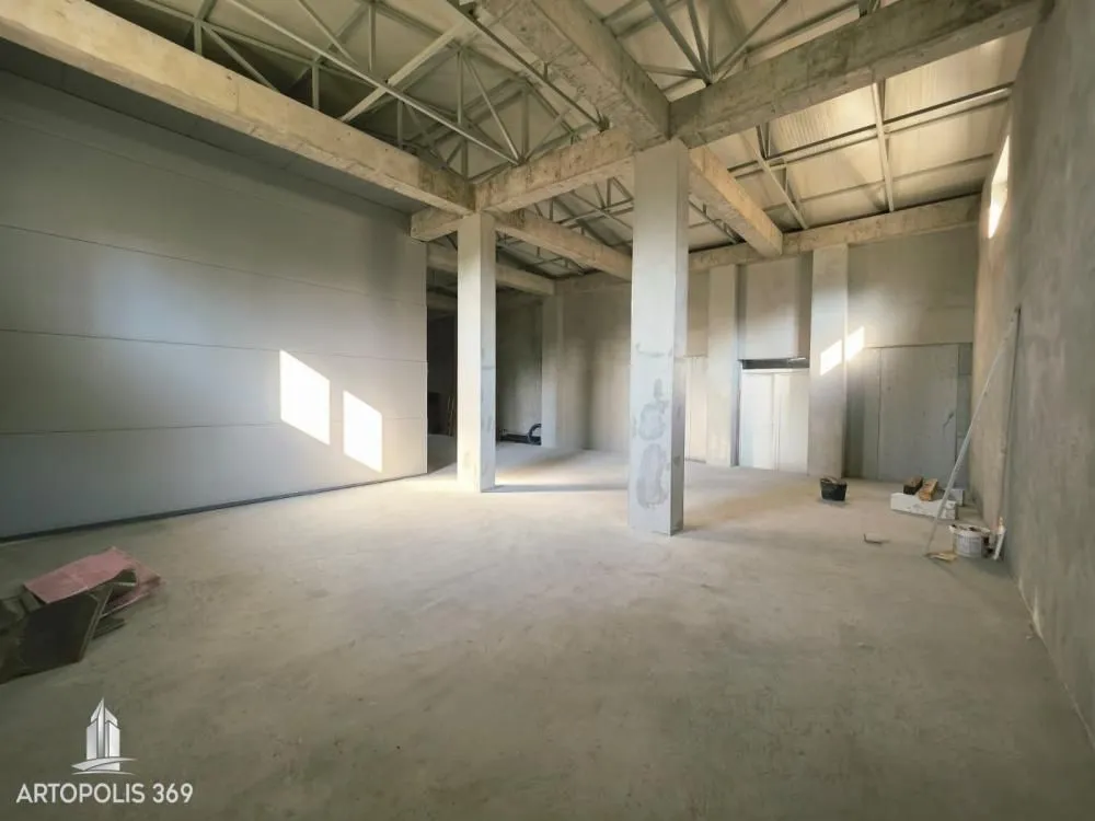 Large unfinished space under construction with concrete pillars and a high ceiling.